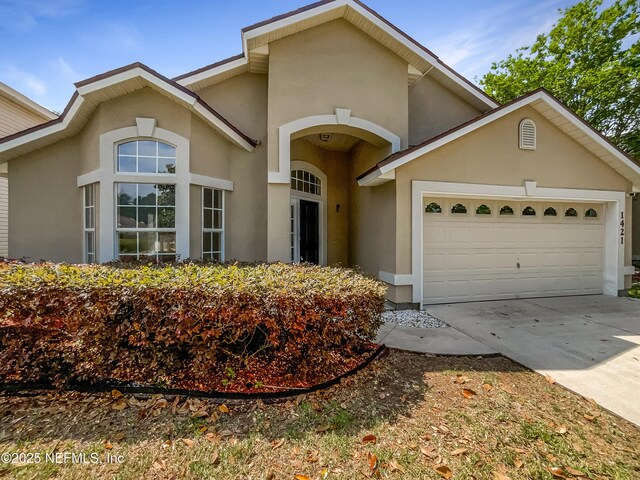 1421 Woodland View Dr, Fleming Island, FL 32003 - view of front of property featuring concrete driveway, a garage, and stucco siding