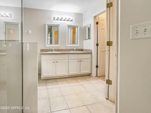 1421 Woodland View Dr, Fleming Island, FL 32003 - bathroom with double vanity, a textured ceiling, a sink, and tile patterned flooring