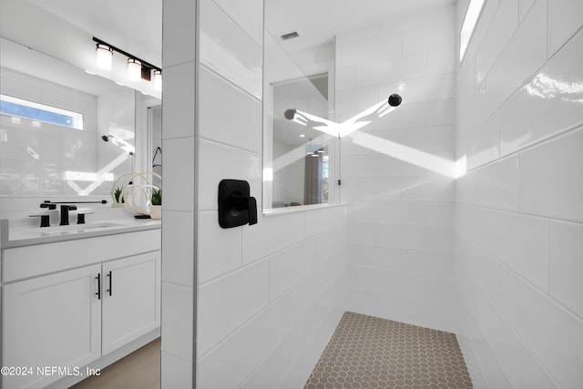 bathroom featuring a tile shower and vanity