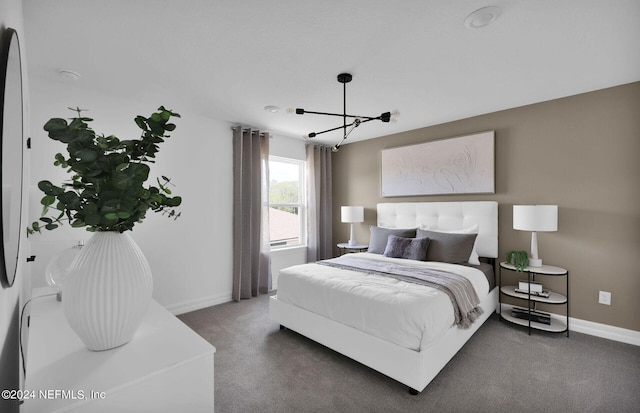 bedroom with a notable chandelier and dark colored carpet