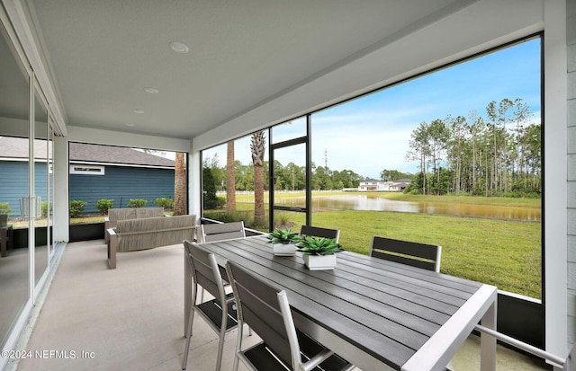 sunroom / solarium featuring a water view