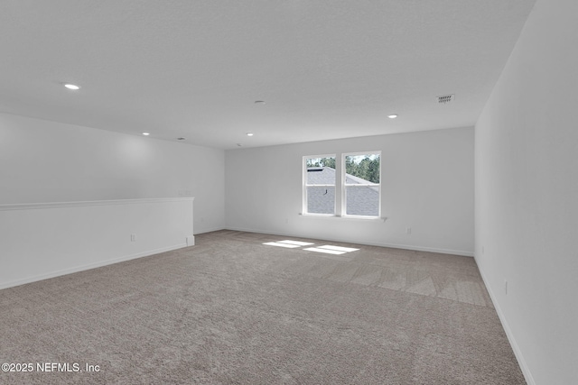 spare room with light carpet, baseboards, visible vents, and recessed lighting