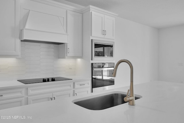 kitchen featuring light countertops, backsplash, a sink, premium range hood, and black appliances