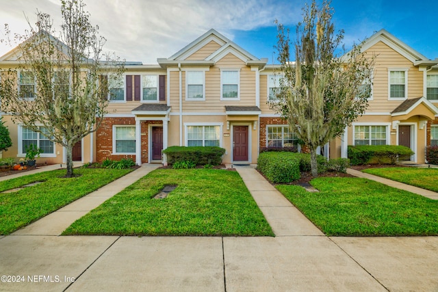 townhome / multi-family property featuring a front lawn