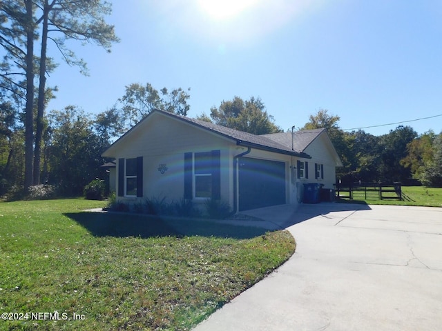 view of side of property with a lawn and a garage