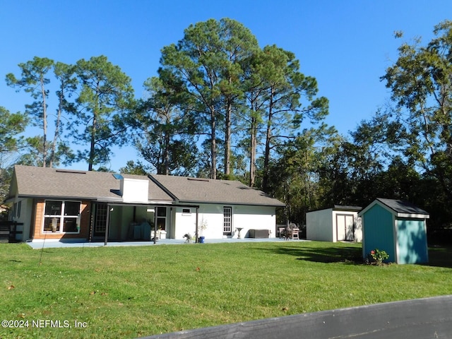 view of front of house with a front yard, a shed, and a patio area