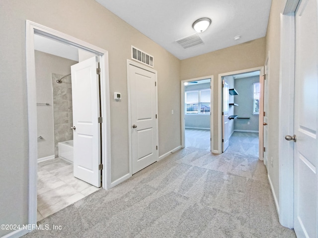 hallway featuring light colored carpet