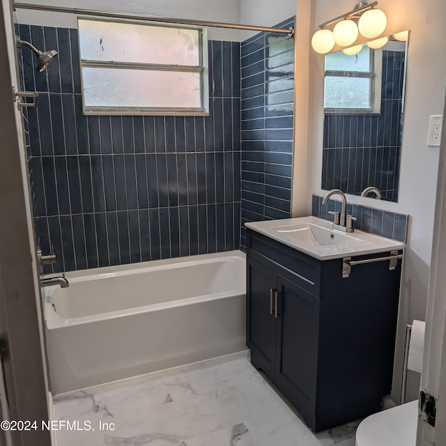 bathroom featuring toilet, marble finish floor, shower / washtub combination, and vanity