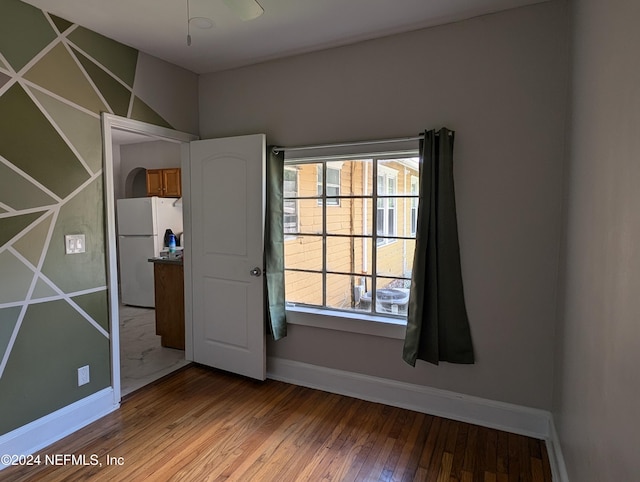 unfurnished room with wood-type flooring and baseboards