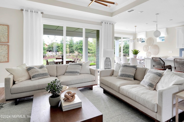 living room with an inviting chandelier and ornamental molding