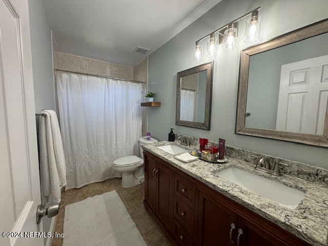 bathroom featuring tile patterned floors, a shower with curtain, vanity, and toilet