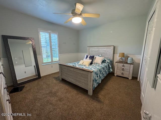 bedroom featuring ceiling fan, a closet, and dark colored carpet