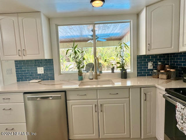 kitchen with sink, decorative backsplash, light stone counters, white cabinetry, and stainless steel appliances