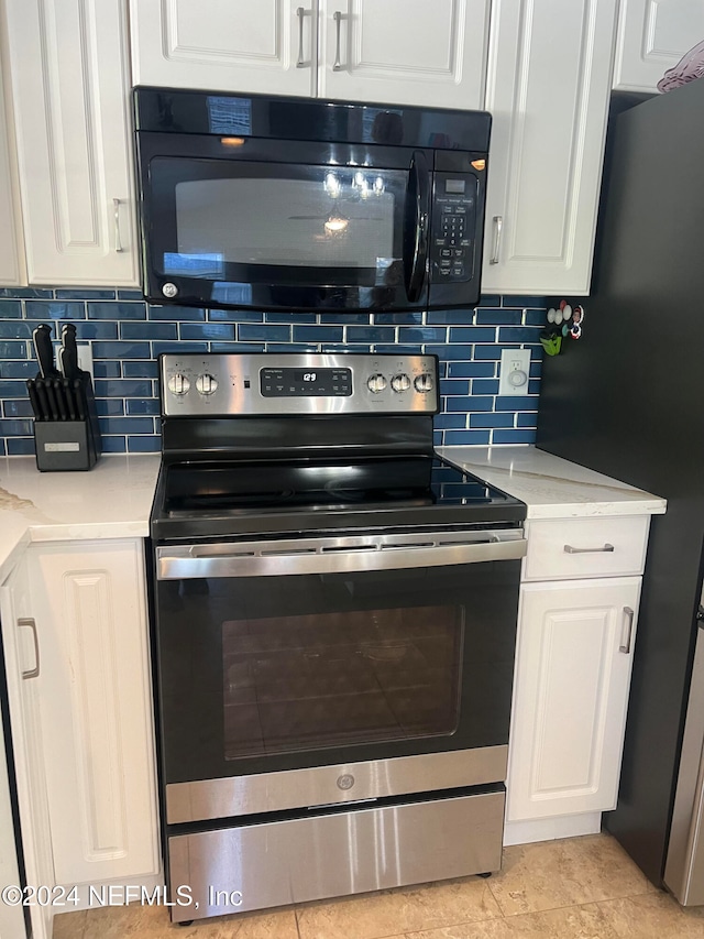 kitchen featuring white cabinets, appliances with stainless steel finishes, decorative backsplash, and light stone counters