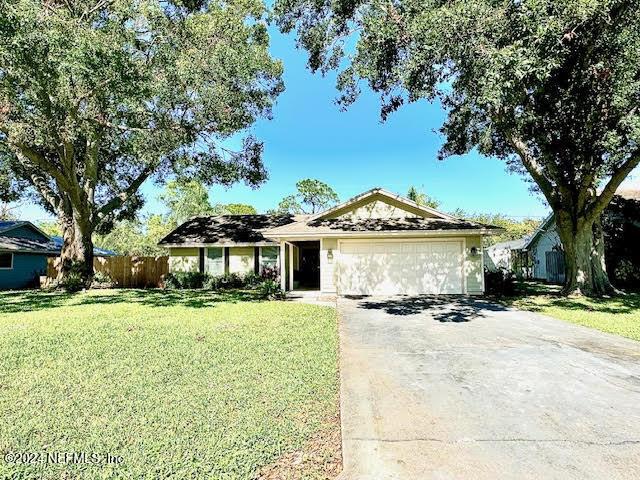 ranch-style house featuring a garage and a front lawn