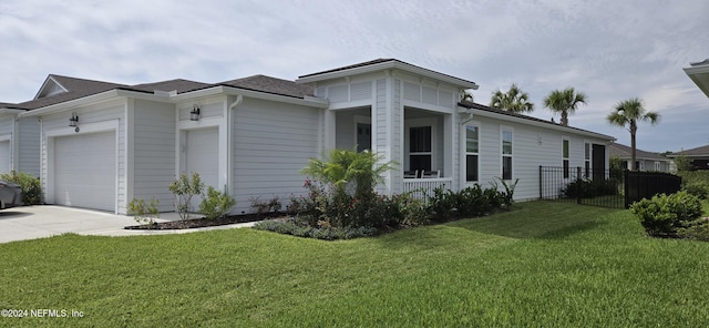 view of side of property with a garage, concrete driveway, a yard, and fence