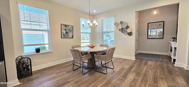 dining area featuring a notable chandelier, dark wood-type flooring, and baseboards