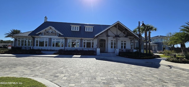 view of front of home with a standing seam roof, a chimney, and metal roof