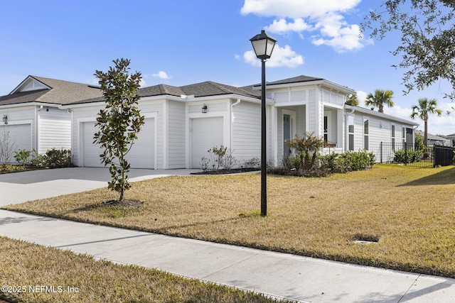 view of front of home with a garage, driveway, a front yard, and fence