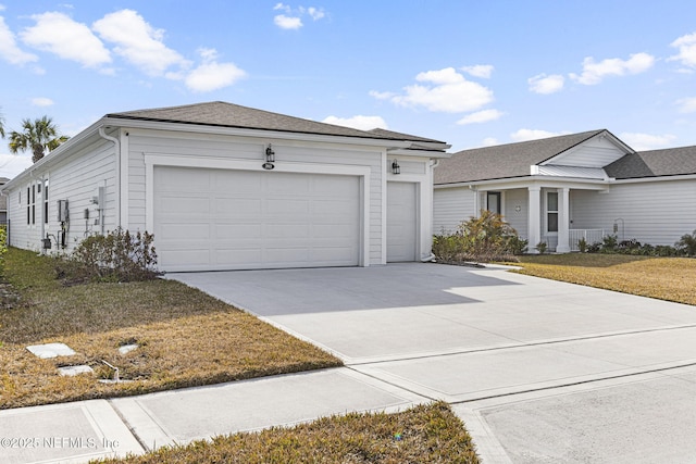 view of front facade featuring an attached garage, concrete driveway, and a front yard