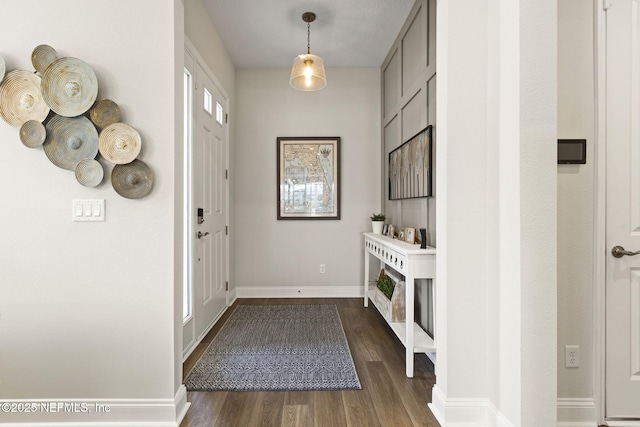 entrance foyer featuring a fireplace, baseboards, and dark wood-style flooring