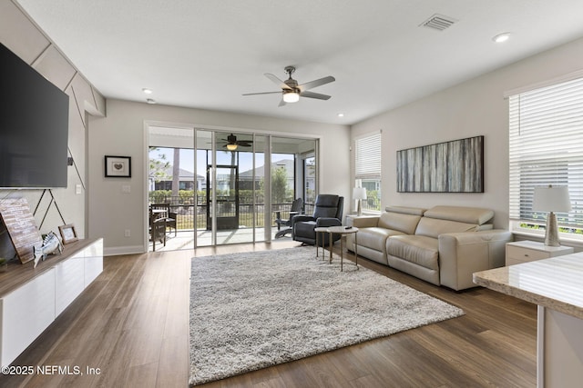 living area featuring baseboards, dark wood-type flooring, visible vents, and recessed lighting