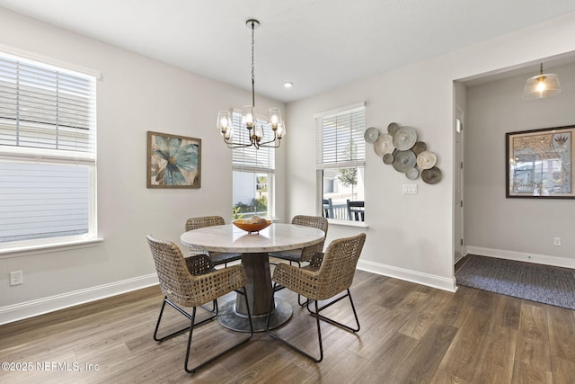 dining area with a notable chandelier, baseboards, and wood finished floors