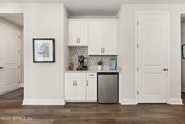 bar featuring refrigerator, dark wood finished floors, backsplash, and baseboards