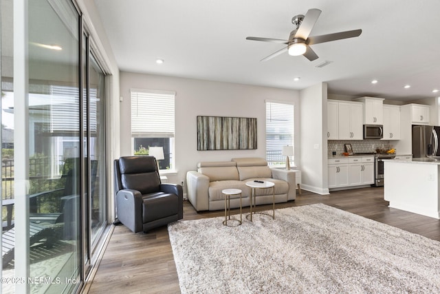 living room featuring dark wood-type flooring, recessed lighting, visible vents, and ceiling fan