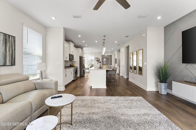 living area with visible vents, dark wood-style flooring, and a wealth of natural light