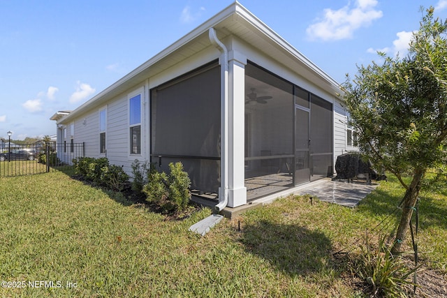 view of property exterior with a sunroom, a yard, and fence