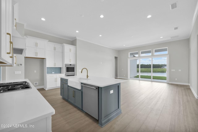 kitchen featuring white cabinets, gray cabinets, an island with sink, and stainless steel appliances