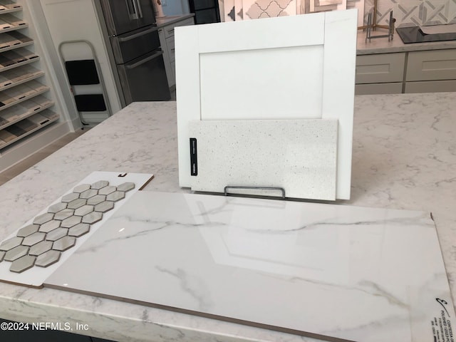 room details with light stone countertops, gray cabinets, and tasteful backsplash