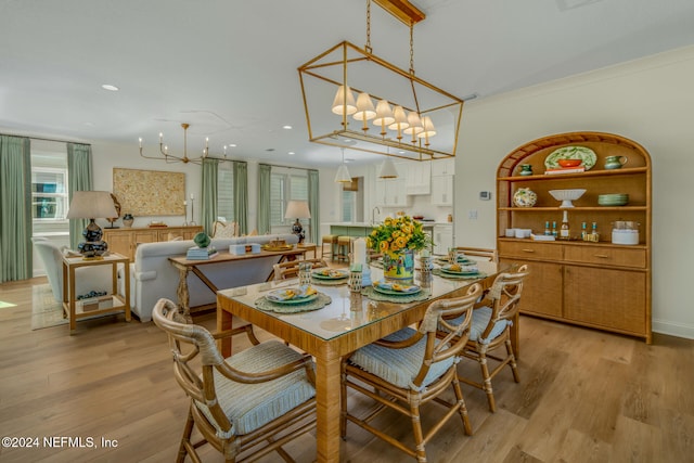 dining space with light hardwood / wood-style floors, built in features, sink, and ornamental molding