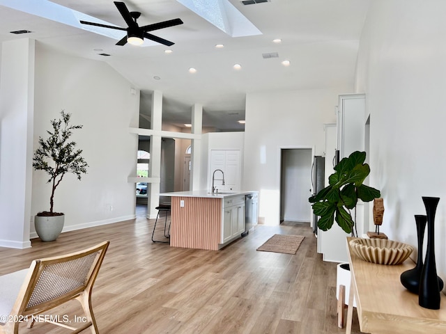 kitchen featuring a kitchen island with sink, sink, ceiling fan, light hardwood / wood-style floors, and white cabinetry