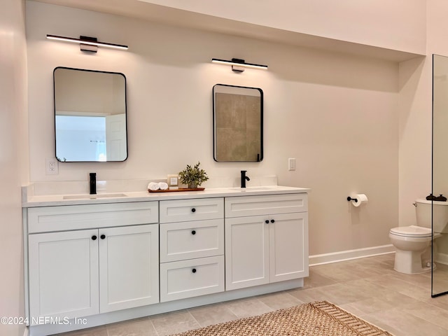 bathroom with tile patterned flooring, vanity, and toilet