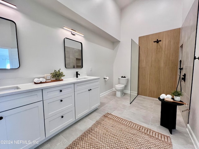 bathroom featuring a shower, vanity, toilet, and tile patterned flooring