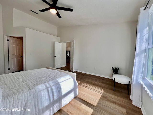 bedroom featuring ceiling fan, light hardwood / wood-style floors, and lofted ceiling