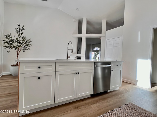 kitchen featuring white cabinets, light wood-type flooring, sink, and vaulted ceiling