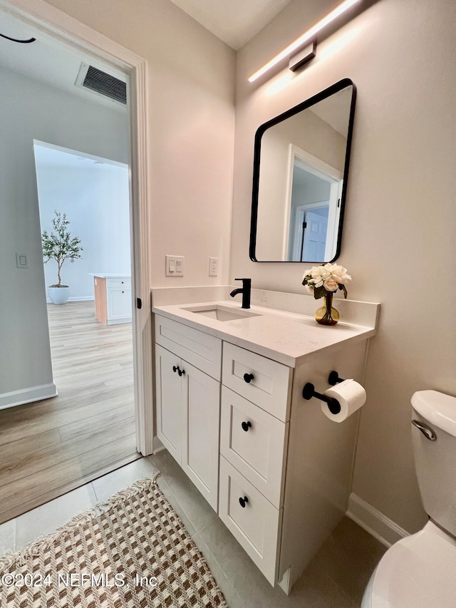 bathroom featuring toilet, vanity, and hardwood / wood-style flooring