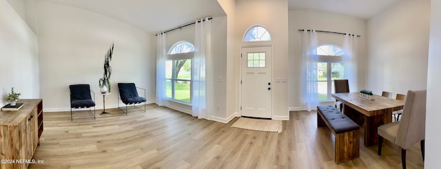 foyer entrance featuring plenty of natural light, light hardwood / wood-style floors, and high vaulted ceiling