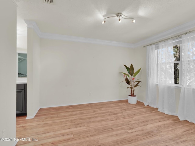 unfurnished room featuring crown molding and light wood-type flooring