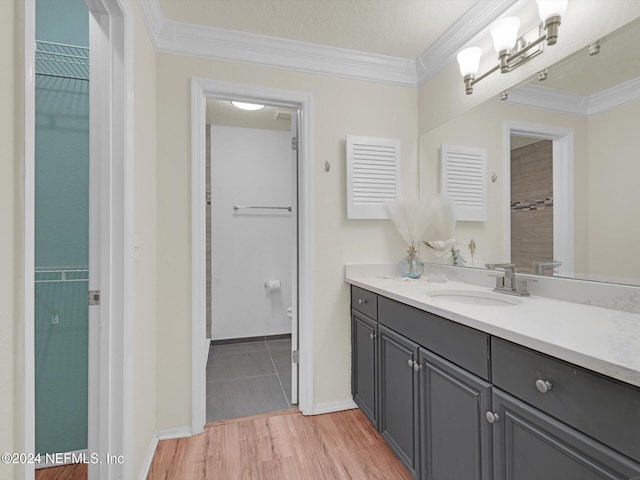 bathroom featuring vanity, hardwood / wood-style floors, crown molding, and toilet