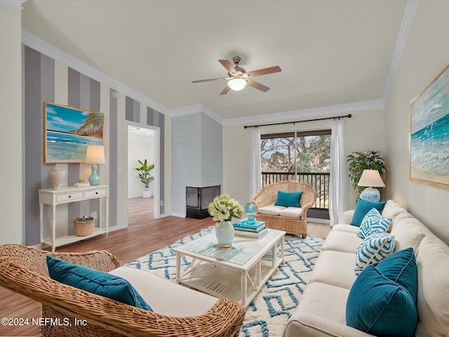 living room featuring ornamental molding, ceiling fan, and light wood-type flooring