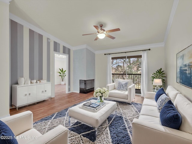 living room with ornamental molding, wood-type flooring, and ceiling fan