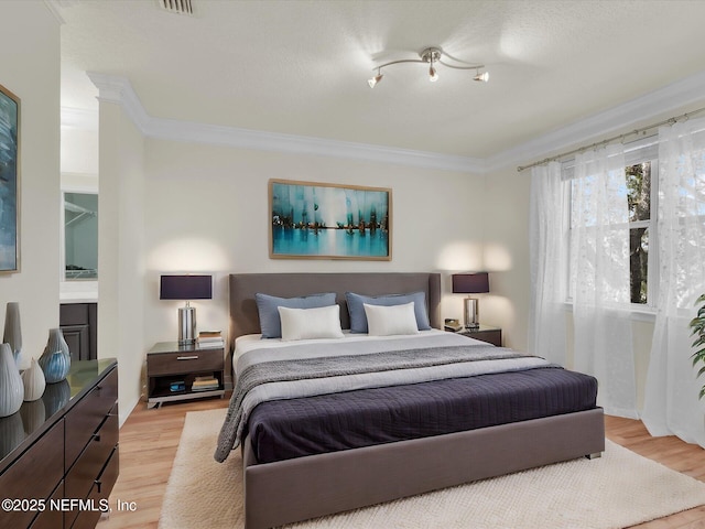 bedroom featuring ornamental molding and light hardwood / wood-style flooring