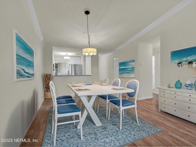 dining space featuring crown molding, hardwood / wood-style flooring, and a textured ceiling