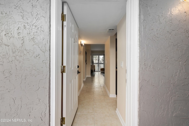 hall featuring light tile patterned flooring