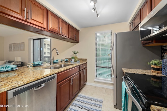 kitchen featuring sink, light stone counters, ventilation hood, light tile patterned floors, and appliances with stainless steel finishes