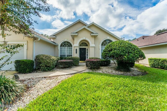 view of front of property featuring a garage and a front lawn